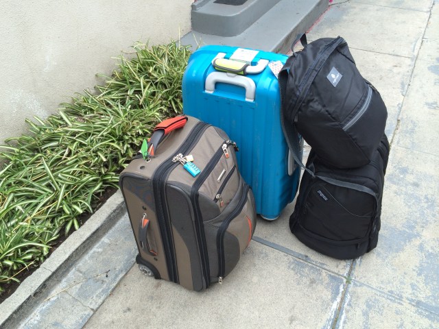 two rolling suitcases, two small backpacks